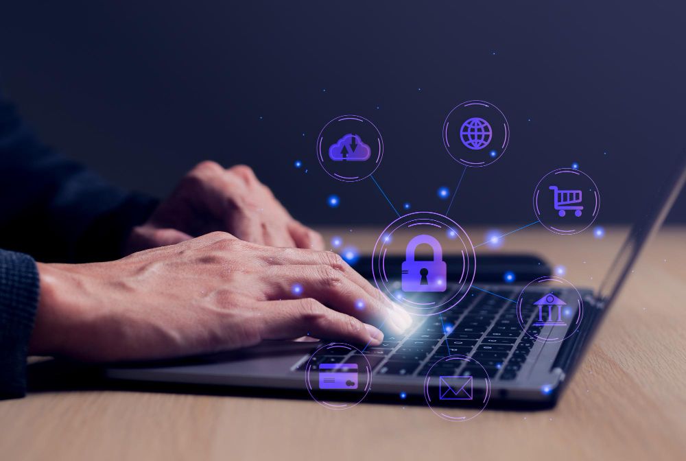 Mãos digitando em um notebook com ícones digitais de segurança e serviços conectados, representando proteção de dados e segurança digital nos sistemas da Alterdata.